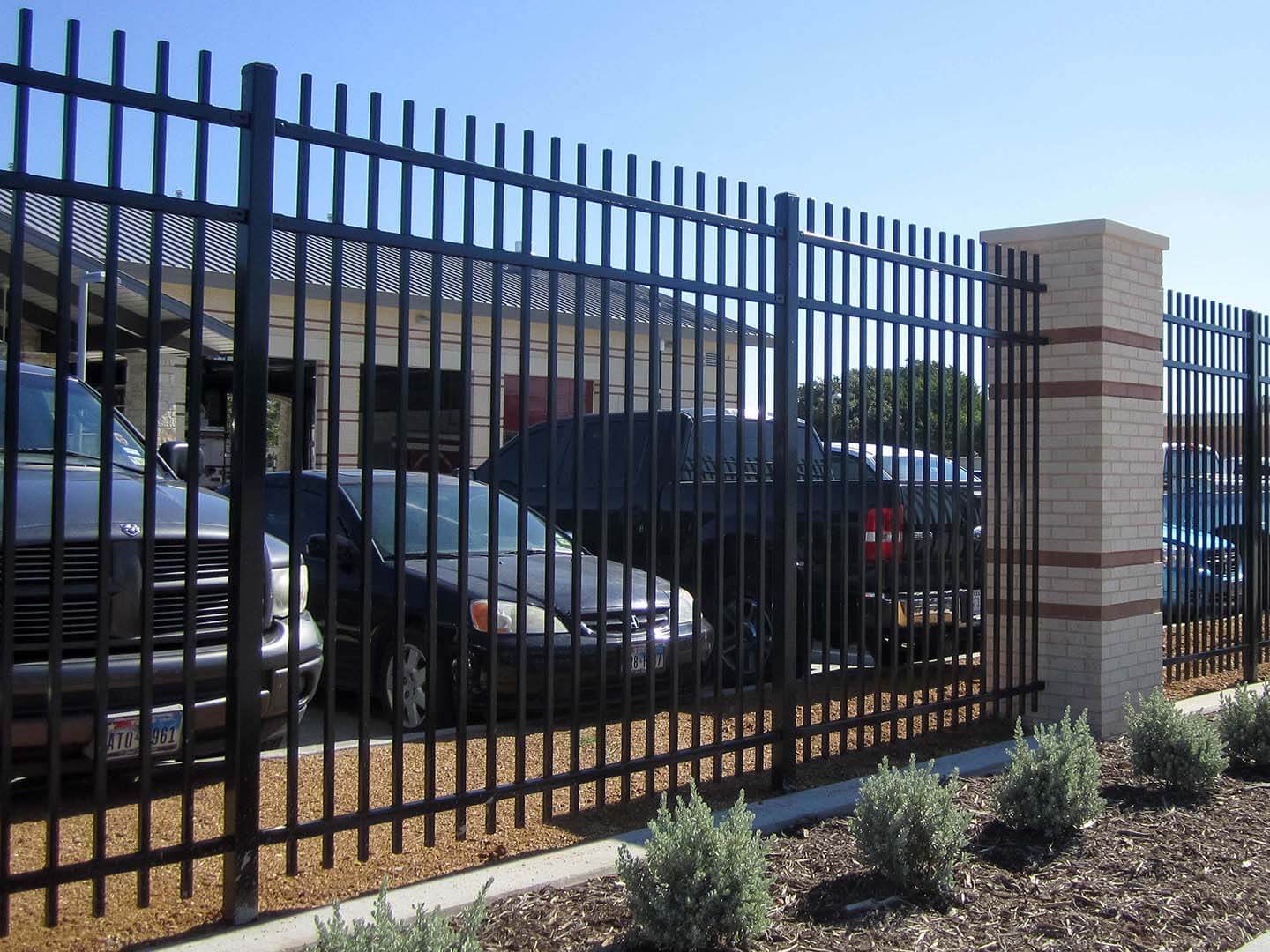 3 rail metal fence installed around a commercial parking lot in Colorado