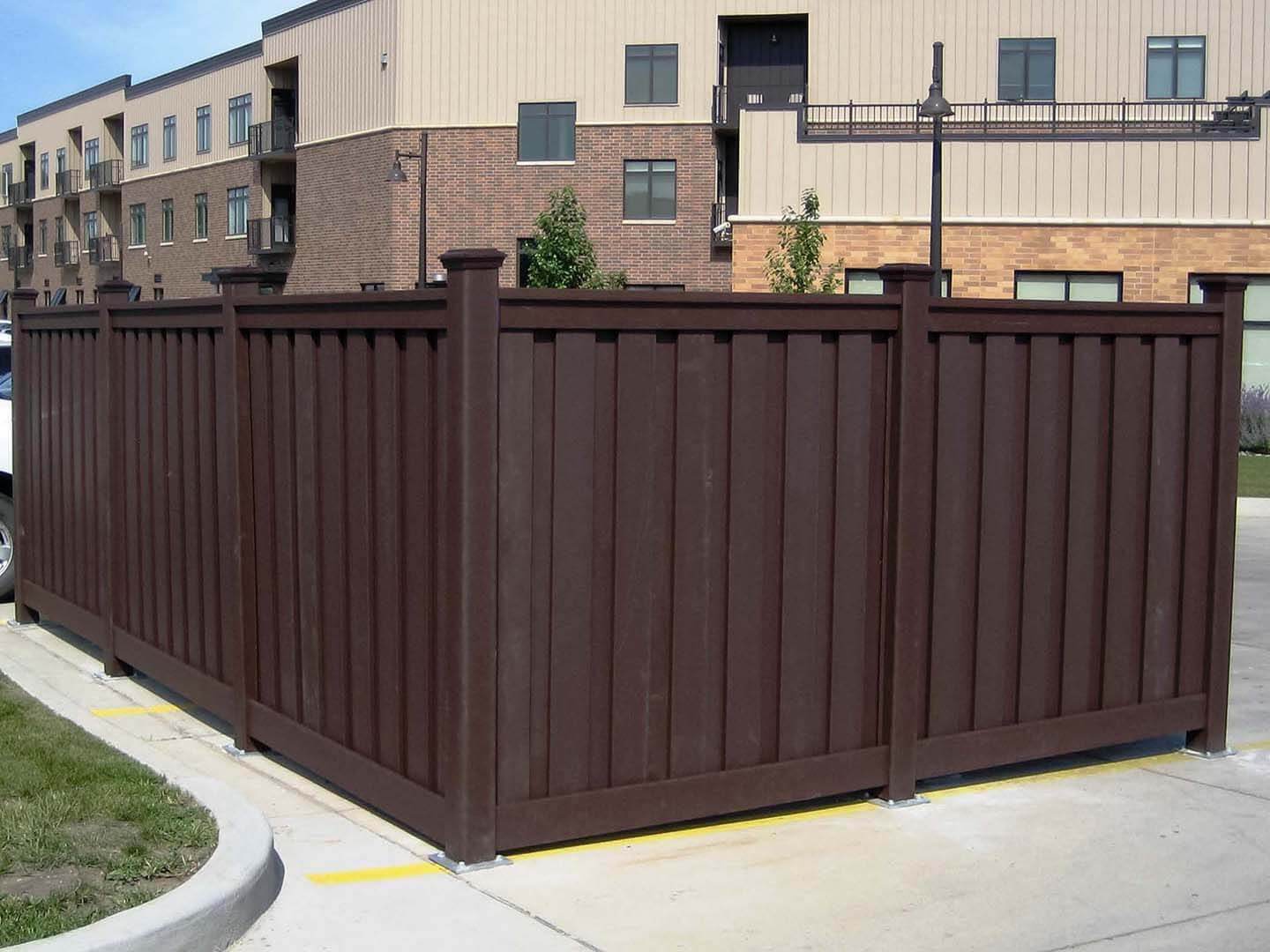 Dark brown composite fence installed as a dumpster enclosure in Colorado