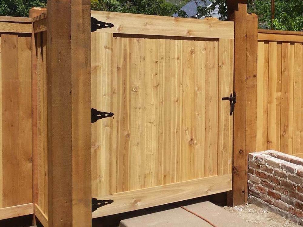 Full privacy board on board wood fence with entry gate installed around a home in Colorado